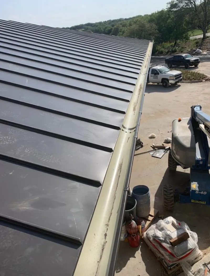 Standing seam panel and gutter detail on a metal roofing jobsite in Walker